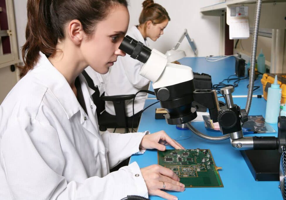 woman looking into microscope