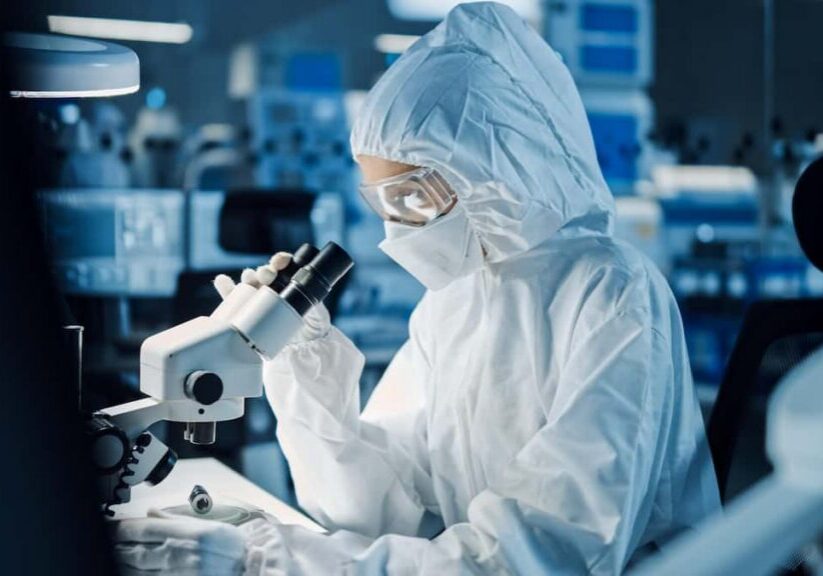 technician looking through microscope for quality control